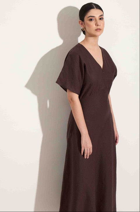 Woman wearing a brown dress against a white background